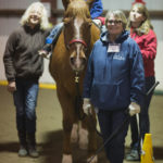 three women and a girl with a horse
