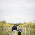 man and woman walking in a vineyard