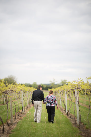 man and woman walking in a vineyard