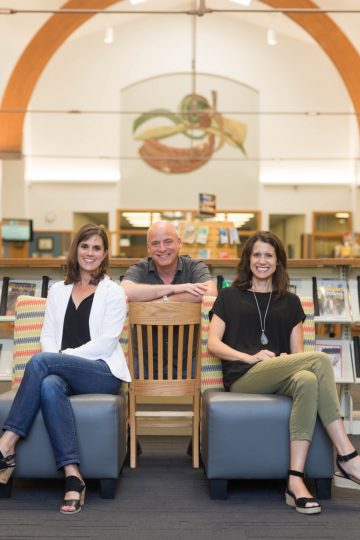 two women and a man at the library