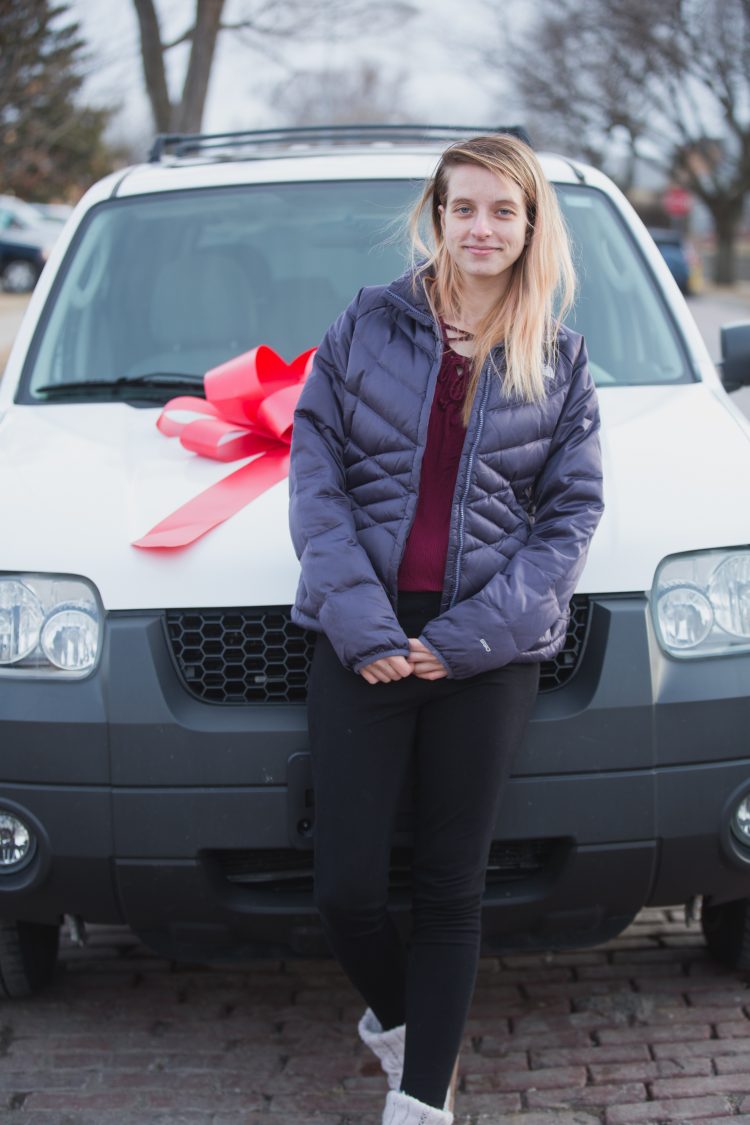 young lady in front of a car