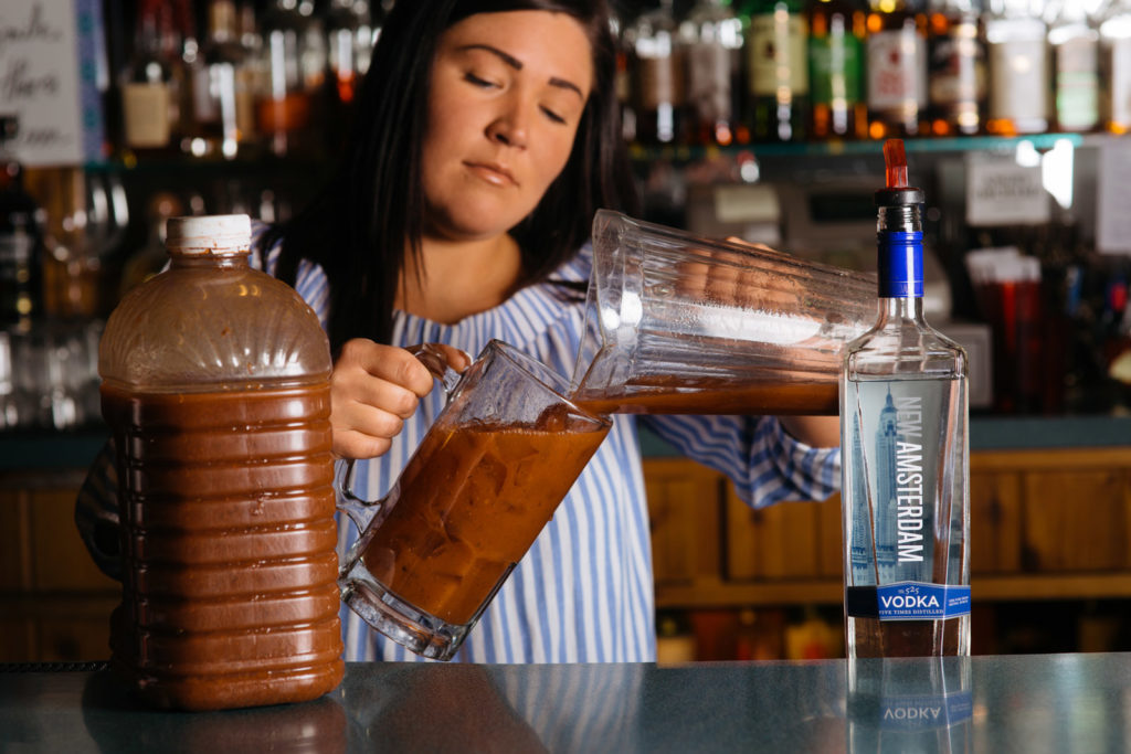 woman bartender prepping cocktail