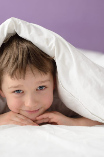 Boy under bed covers