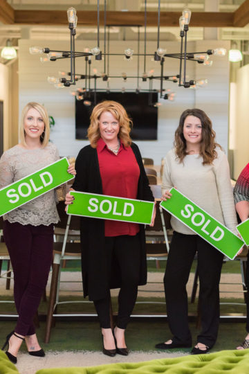 Better Homes staff holding sold signs