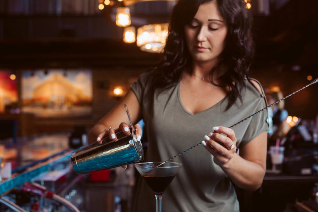 woman bartender pouring cocktail