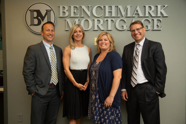 people standing by company logo