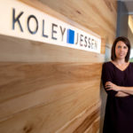 woman next to company sign