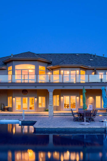 home lit up at night with a pool