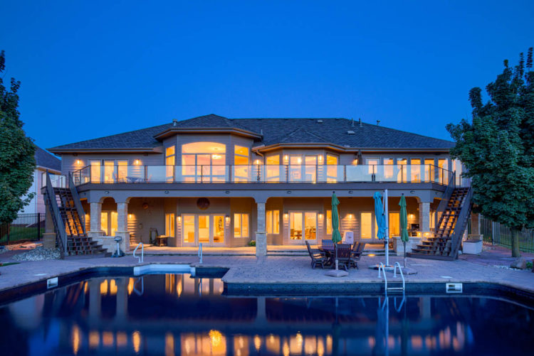 home lit up at night with a pool