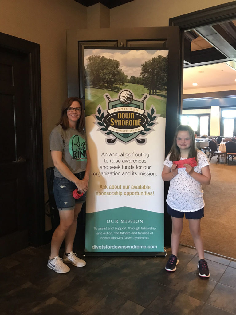 woman and girl in front of a sign