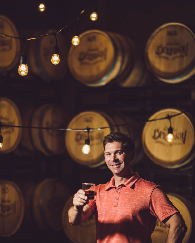 Brickway owner in front of barrels