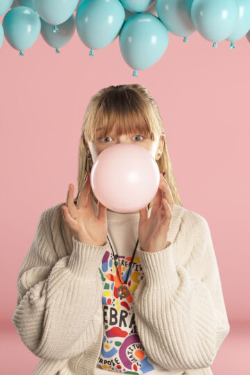 girl blowing a balloon up