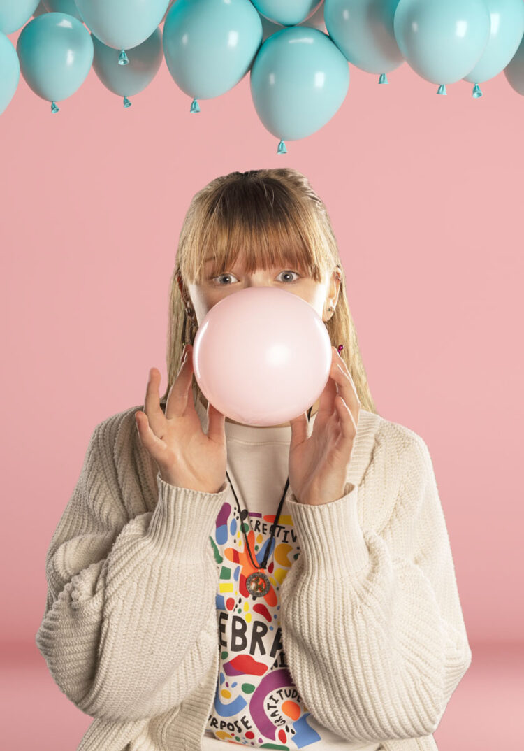 girl blowing a balloon up